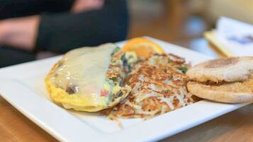Um prato com omelete, hash browns e torradas.