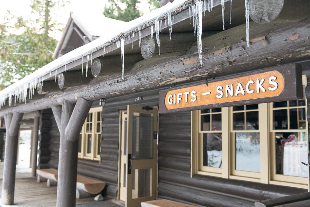 Un edificio de madera rústico con un letrero que dice "GIFTS - SNACKS".