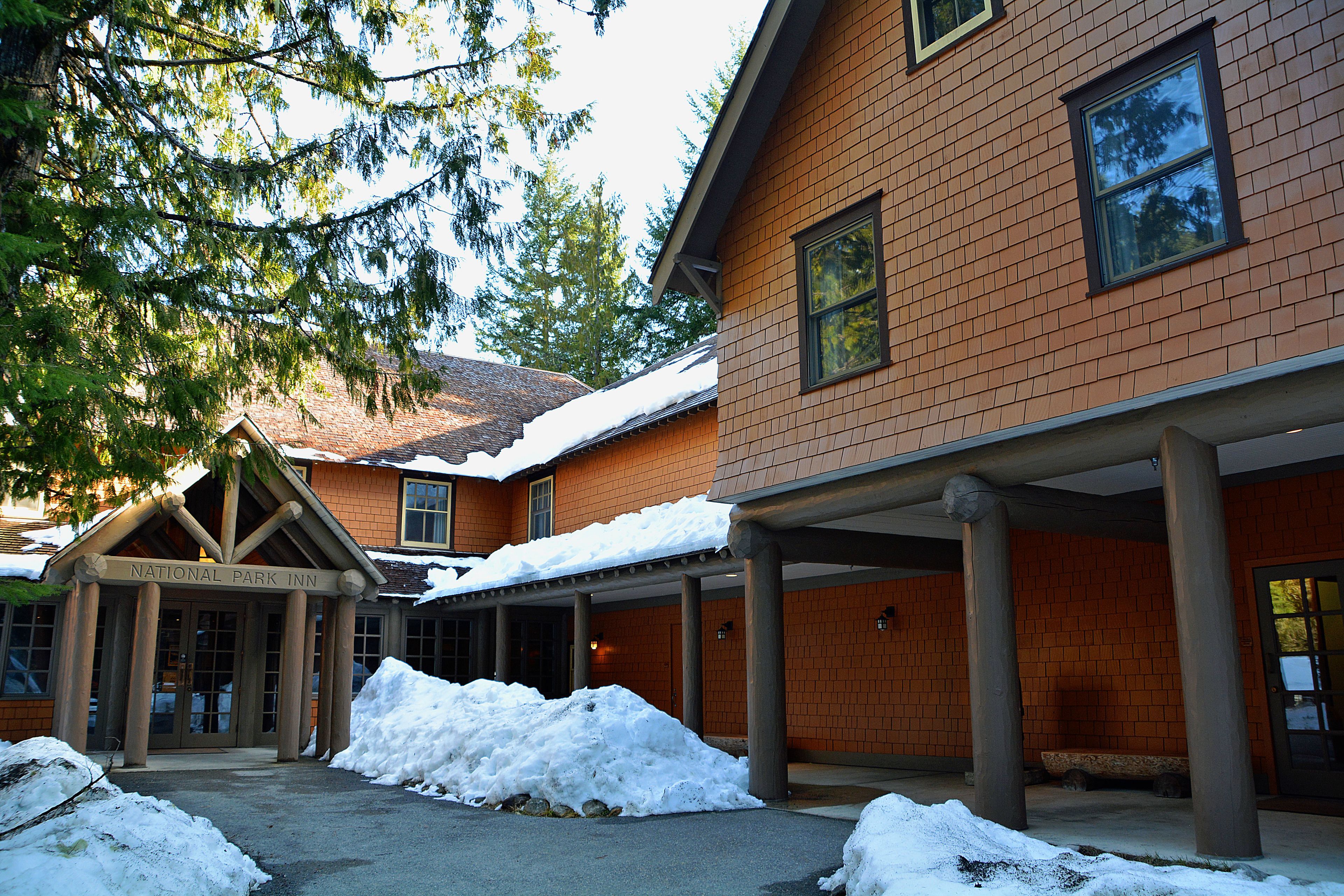 A brick building with a covered entrance and snow accumulation.