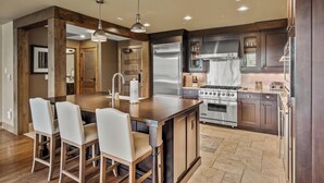 Una cocina moderna con una isla central, electrodomésticos de acero inoxidable y muebles de madera.
