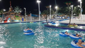 Une zone de piscine où plusieurs personnes utilisent des bouées gonflables.