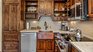 Une cuisine avec des meubles en bois, un réfrigérateur en acier inoxydable, un évier et une cuisinière.