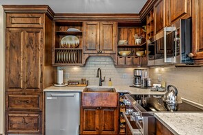 A kitchen with wooden cabinets, a stainless steel refrigerator, a sink, and a stove. - Bear Claw 301 Exceptional On Mountain Condo With Ski-In/Ski-Out Access! (Steamboat Springs)