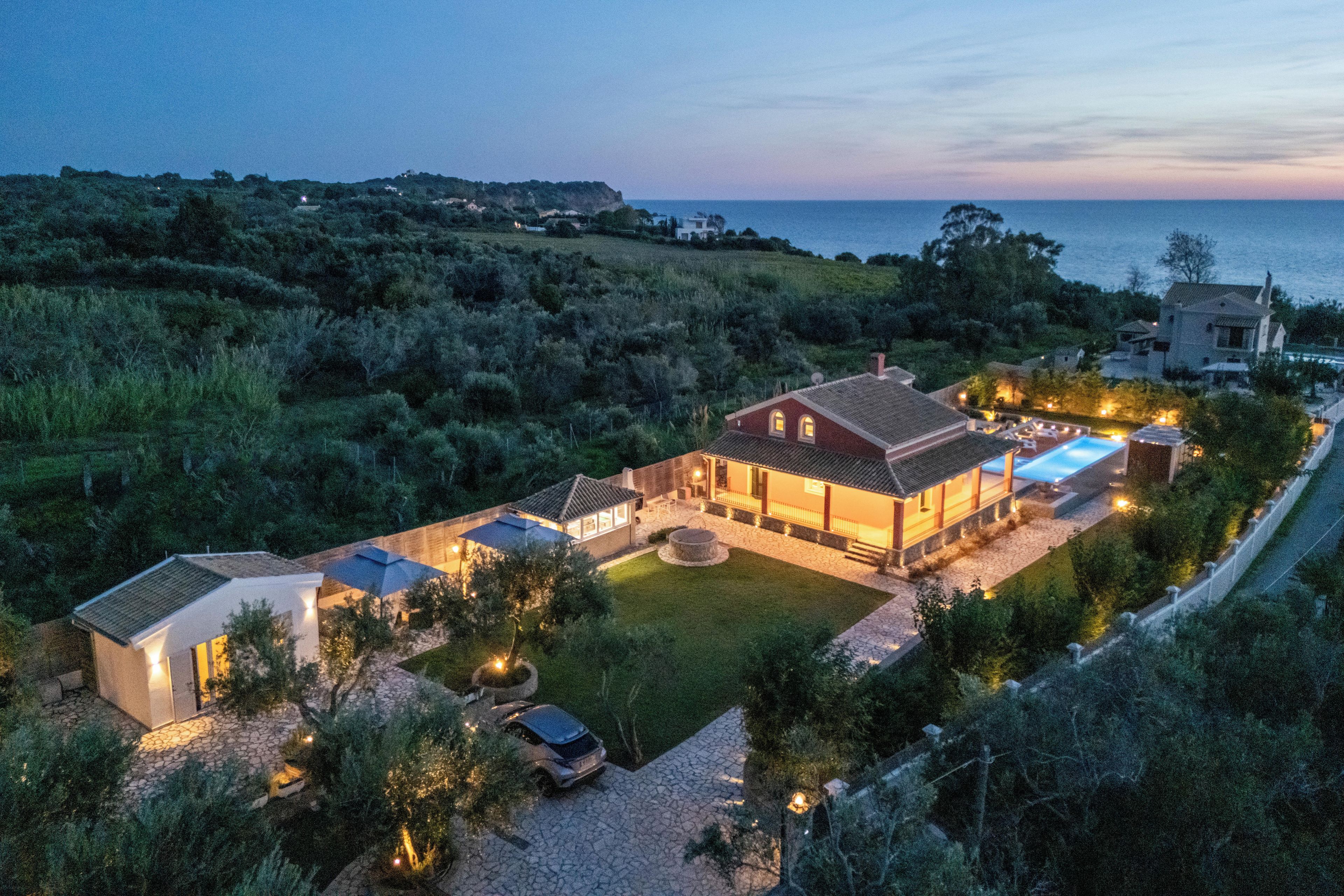 A coastal property with a large house, a swimming pool, and a well-maintained lawn.