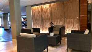 Eine Lobby mit Korbmöbeln, einer Holzwand und einem Fliesenboden.