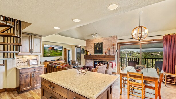 A spacious kitchen with a large island, wooden cabinets, and a fireplace. - Bear Claw 404 Premium On Mountain Condo With Ski-In/Ski-Out Access! (Steamboat Springs)