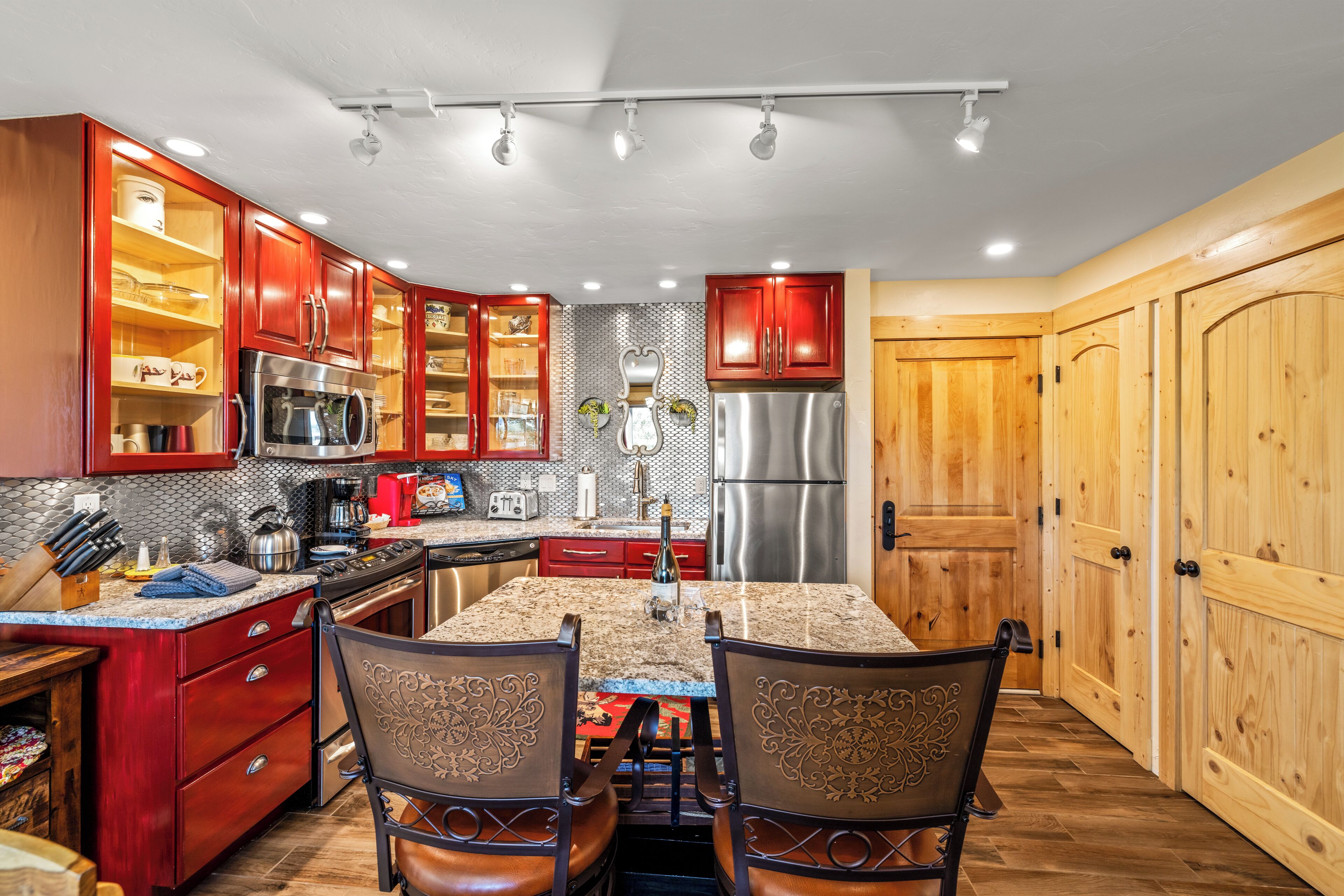 A kitchen with wooden cabinets, stainless steel appliances, and a granite countertop.
