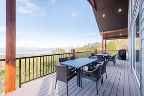 Une terrasse extérieure couverte, dotée d’une table et de chaises, qui offre une vue sur un paysage magnifique.