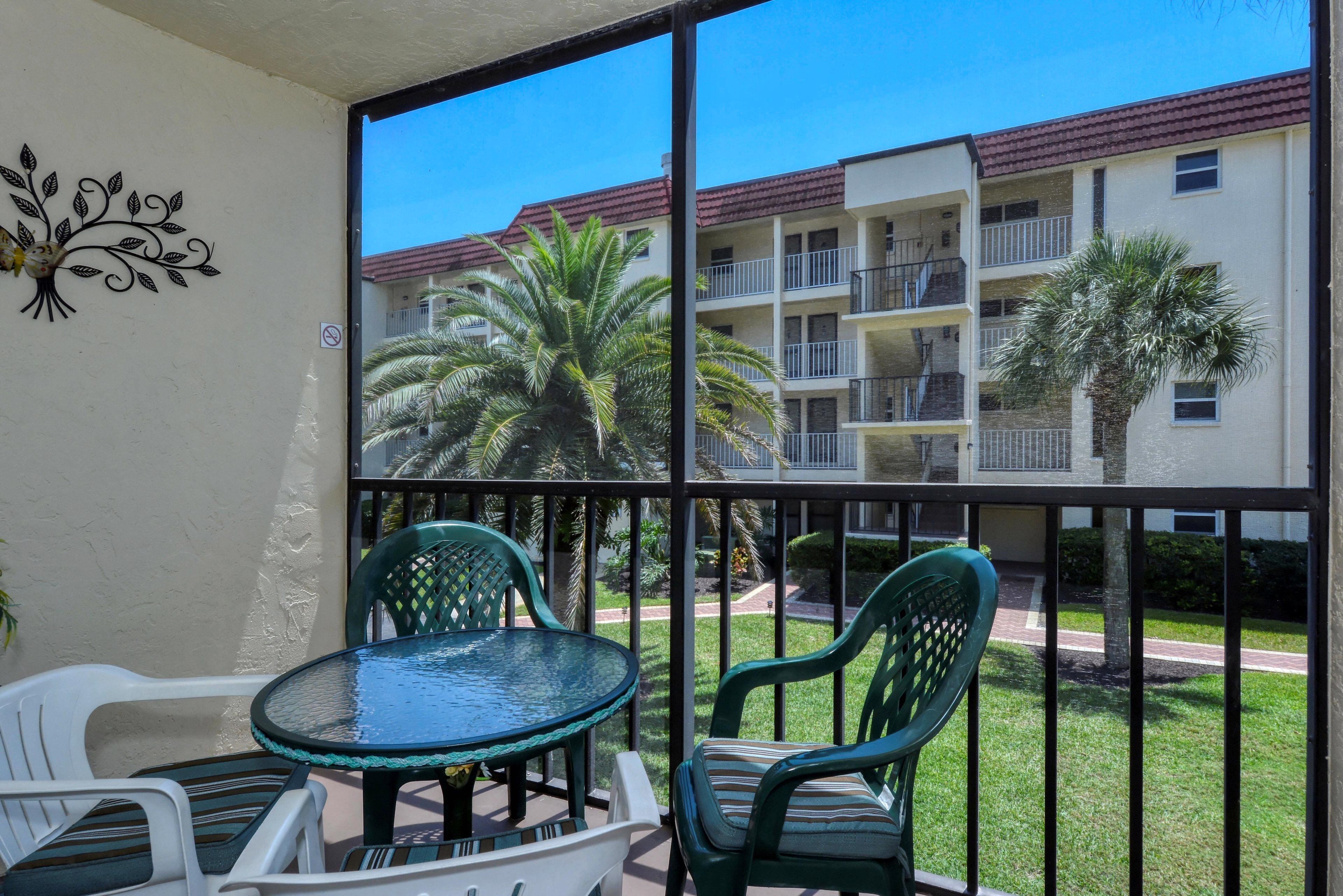 A balcony with a glass door, a round table, and two chairs.