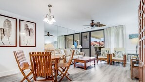 Un salón amplio con un comedor de madera, un sofá y un ventilador de techo.