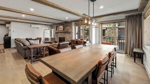 Amplia sala de estar con una gran mesa de comedor de madera, sofás de cuero y una chimenea de piedra.