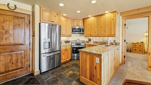 A kitchen with wooden cabinets, stainless steel appliances, and a granite countertop. - Bear Claw 103 Mountain Condo With Ski-In/Ski-Out Access! (Steamboat Springs)