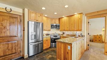 A kitchen with wooden cabinets, stainless steel appliances, and a granite countertop.