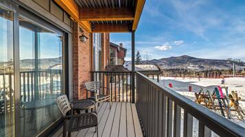 A wooden deck with a glass door leading to a patio area.