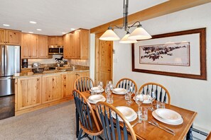 Enjoy meals in this stylish dining area with a table for four, a beautiful artwork, and a pendant light fixture.