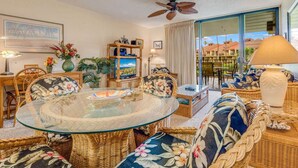 A living room with wicker furniture, a glass table, and a ceiling fan. - Tranquil Courtyard View Condo w/Kitchen Updates, WiFi, Washer/Dryer–#7203 (KIHEI)