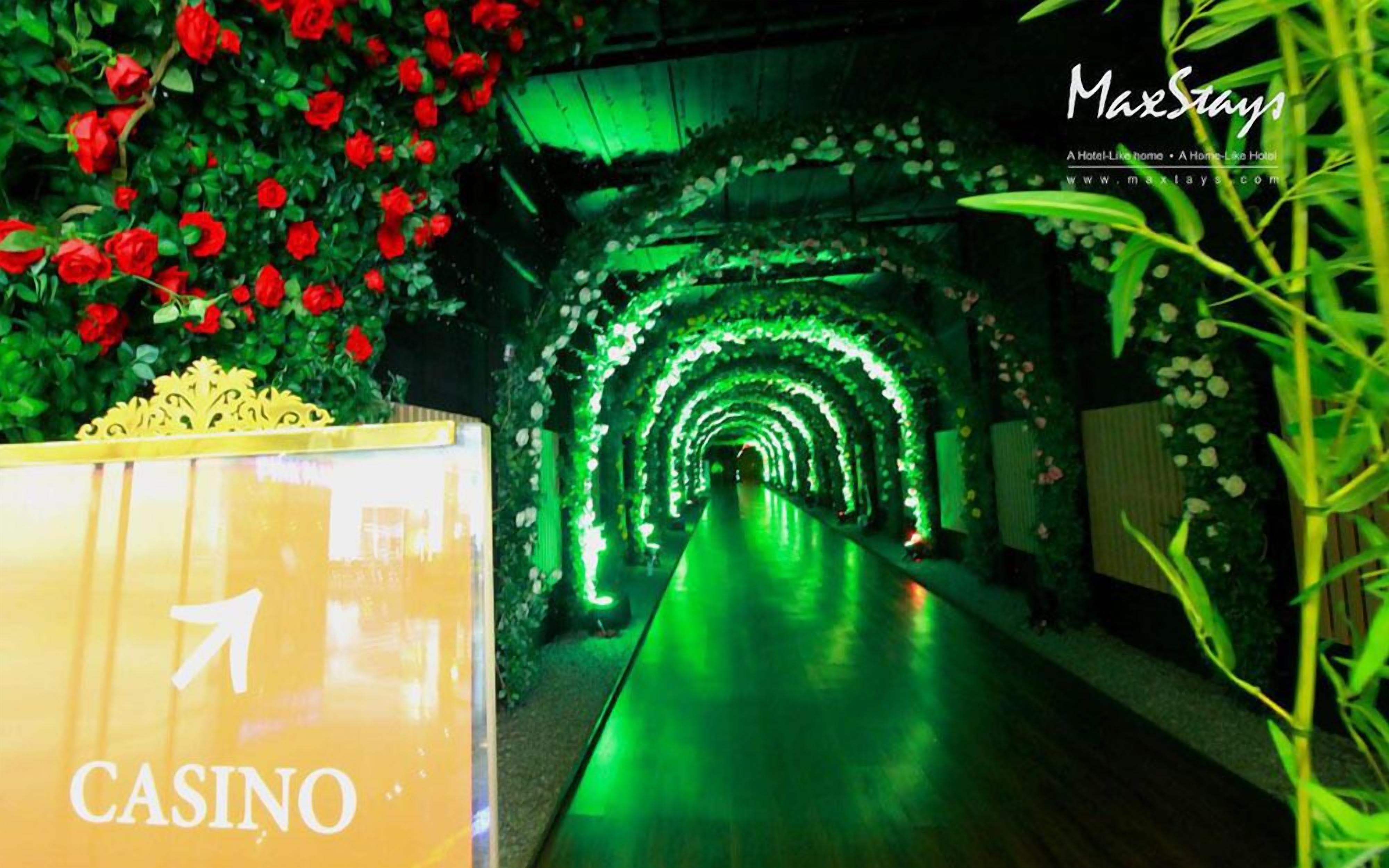 A casino corridor with green lighting and red roses.
