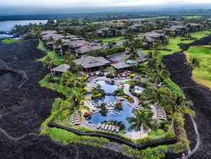 A resort with a central pool, multiple guest villas, and a view of the ocean. - Luxurious Hali'i Kai Townhome with fabulous Ocean views and Private Ocean Club  (Waikoloa Village)