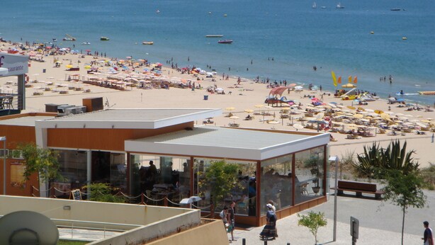 Ein Strand mit Restaurant und Meerblick.