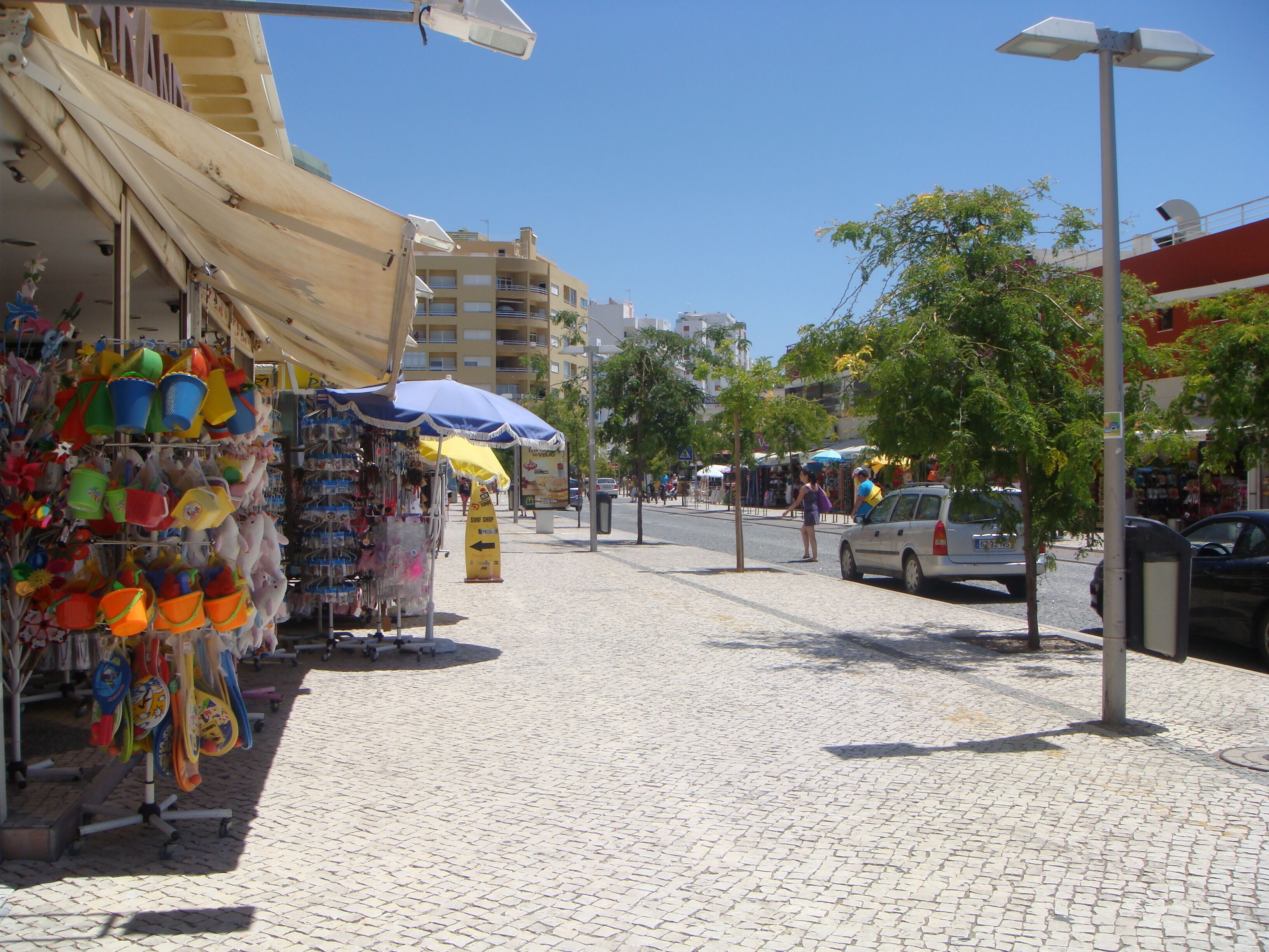 A street with shops, including a beachwear store and a surf shop.