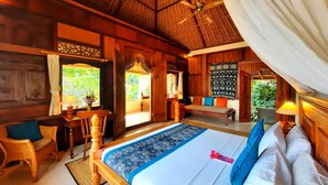 A spacious room with a large bed, wooden furniture, and a ceiling fan. - Alam Indah Ubud (Ubud)