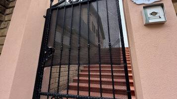 Un cancello carrabile con inferriata, una targa informativa e una telecamera di sicurezza.