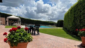 A patio area with a pool, outdoor seating, and potted plants. - Villa Gilda Bracciano with private Pool & A/C (Bracciano, Italia)