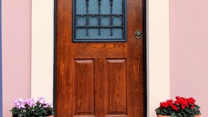 A wooden door with a glass panel and a metal gate, flanked by two potted plants. - Villa Gilda Bracciano with private Pool & A/C (Bracciano, Italia)
