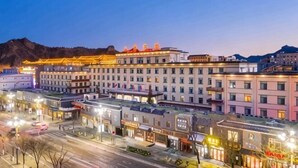 A multi-story hotel with a row of balconies, a central courtyard, and a mountain backdrop. - Mountain Villa Hotel (Chengde)