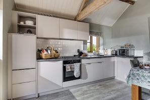 A modern kitchen with white cabinetry, a built-in oven, and a microwave. - Little Owls Barn, Preston Wynne, Herefordshire (Preston Wynne)