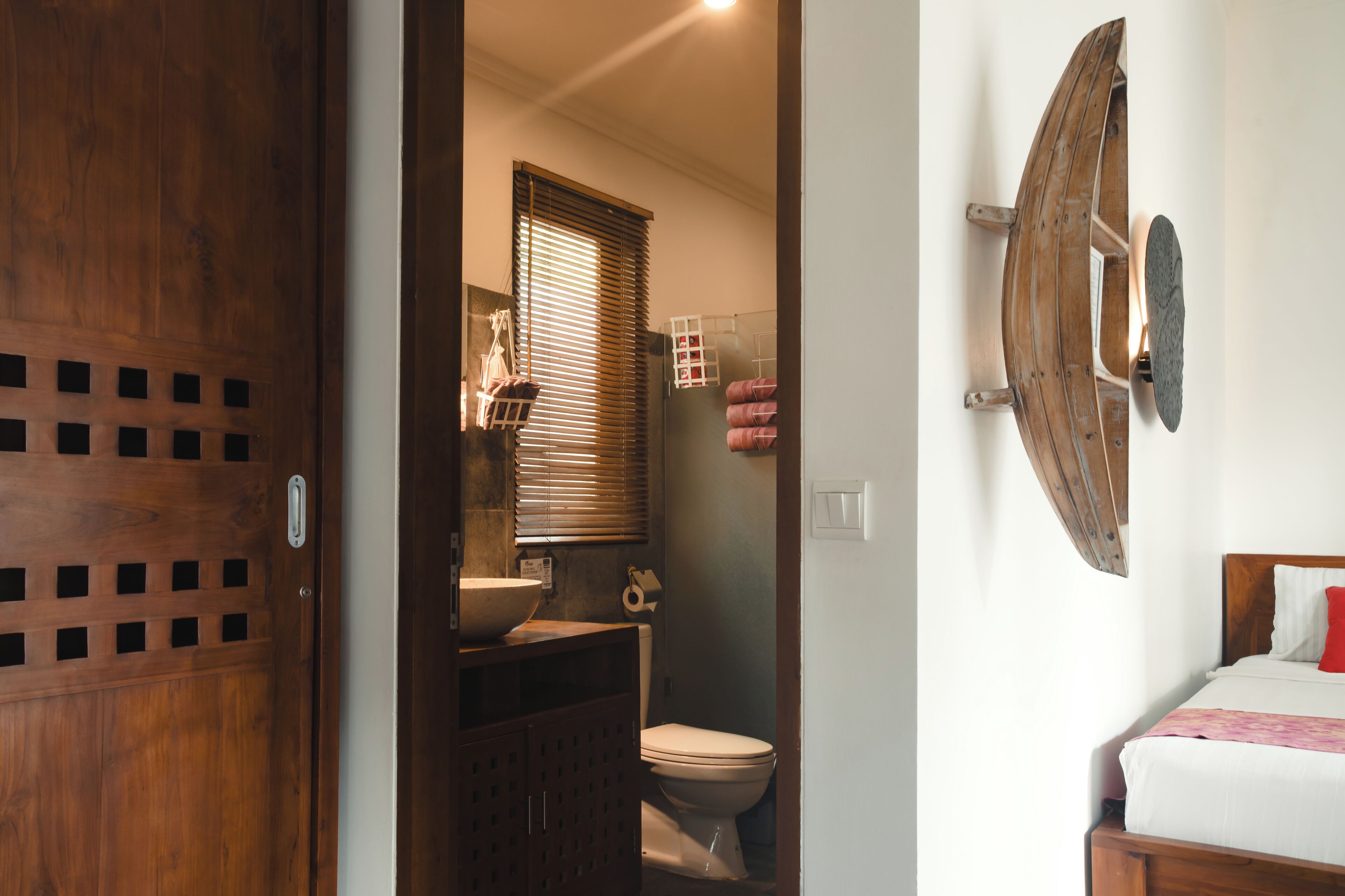 A bathroom with a wooden door, a sink, and a toilet.