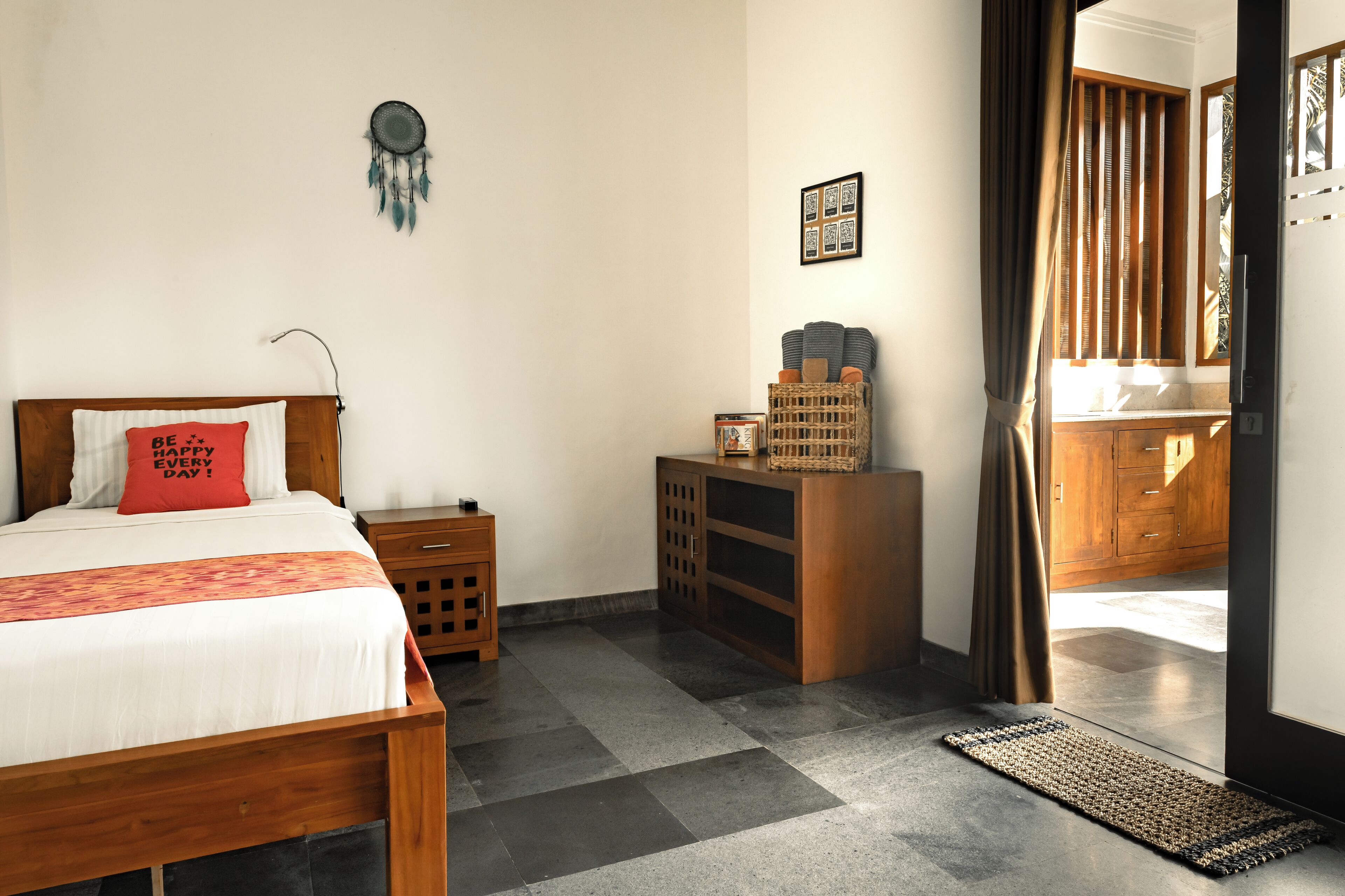 A bedroom with a bed, bedside table, and a small wooden cabinet.
