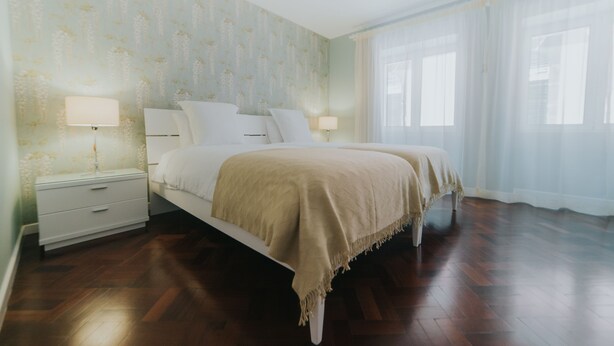 A bedroom with a bed, nightstands, and a window with curtains. - Casa da Calçada - 2nd Floor (Funchal)