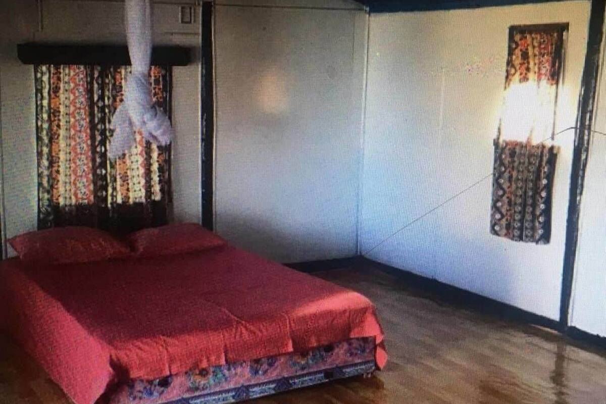 Una habitación con cama, cortinas y ventana.