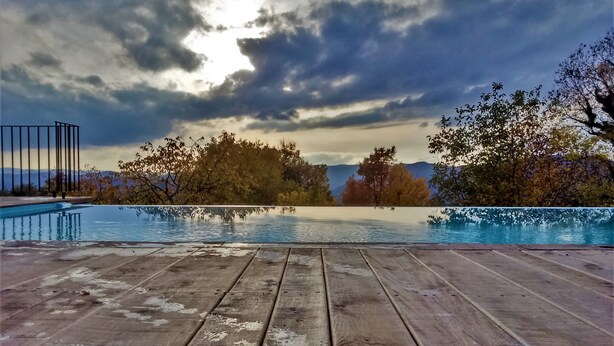 A wooden deck with a pool, surrounded by trees and mountains. - Cute vacation house surrounded by green area (Buzet)