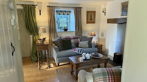 A cozy living room with a sofa, a coffee table, and a fireplace. - Ty Ucha’r Ffordd, Bodnant Estate, Colwyn Bay, Conwy, Wales (Colwyn Bay)