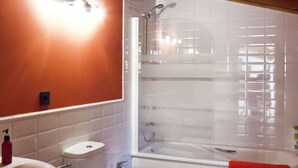 Un baño con una bañera blanca, un inodoro y un lavamanos.