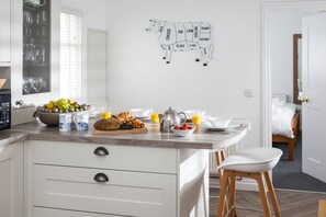 A kitchen with a marble countertop, a fruit bowl, a coffee maker, and a wall map.