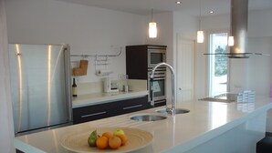 A modern kitchen with a large island, stainless steel appliances, and pendant lighting. - Magnificent luxury villa for 10 to 16 people. - magnificent sea and mountain views (Manilva)