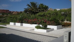 A landscaped garden with white planters and a palm tree. - Magnificent luxury villa for 10 to 16 people. - magnificent sea and mountain views (Manilva)
