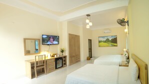A hotel room with a television, a desk with a chair, a wardrobe, two beds, and a painting on the wall. - Hoang Giang Homestay (Ninh Binh)