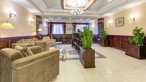 A spacious lobby with a chandelier, sofas, a coffee table, and potted plants. - Bishkek Centrum Hotel (Bishkek)