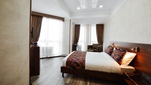 A hotel room with a large bed, a sofa, and a small table. - Bishkek Centrum Hotel (Bishkek)
