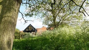A rural house surrounded by lush greenery and a tree. - Miller's Loft, A romantic retreat for 2 (Erpingham)