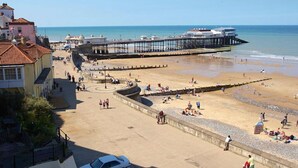 A beach with a pier, a parking area, and buildings in the background. - Miller's Loft, A romantic retreat for 2 (Erpingham)