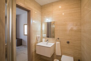 Tina con regadera, secadora de cabello, bidet, toallas 