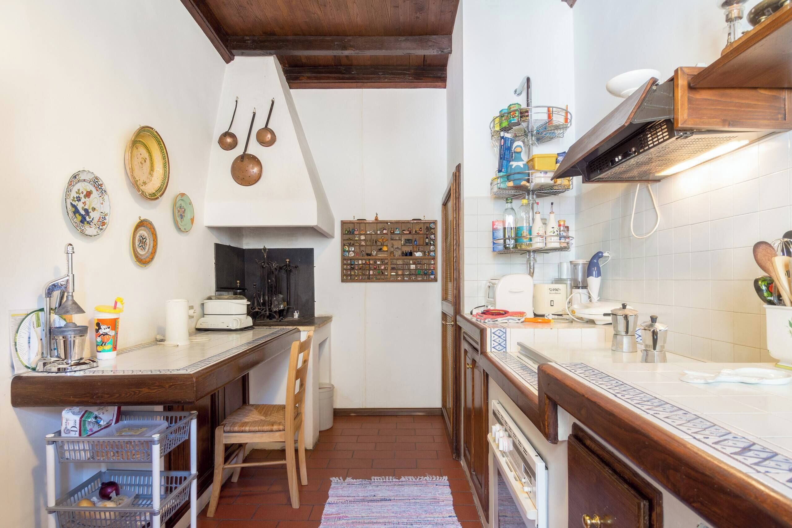 A kitchen with a wooden counter, a coffee machine, and a variety of kitchen utensils.