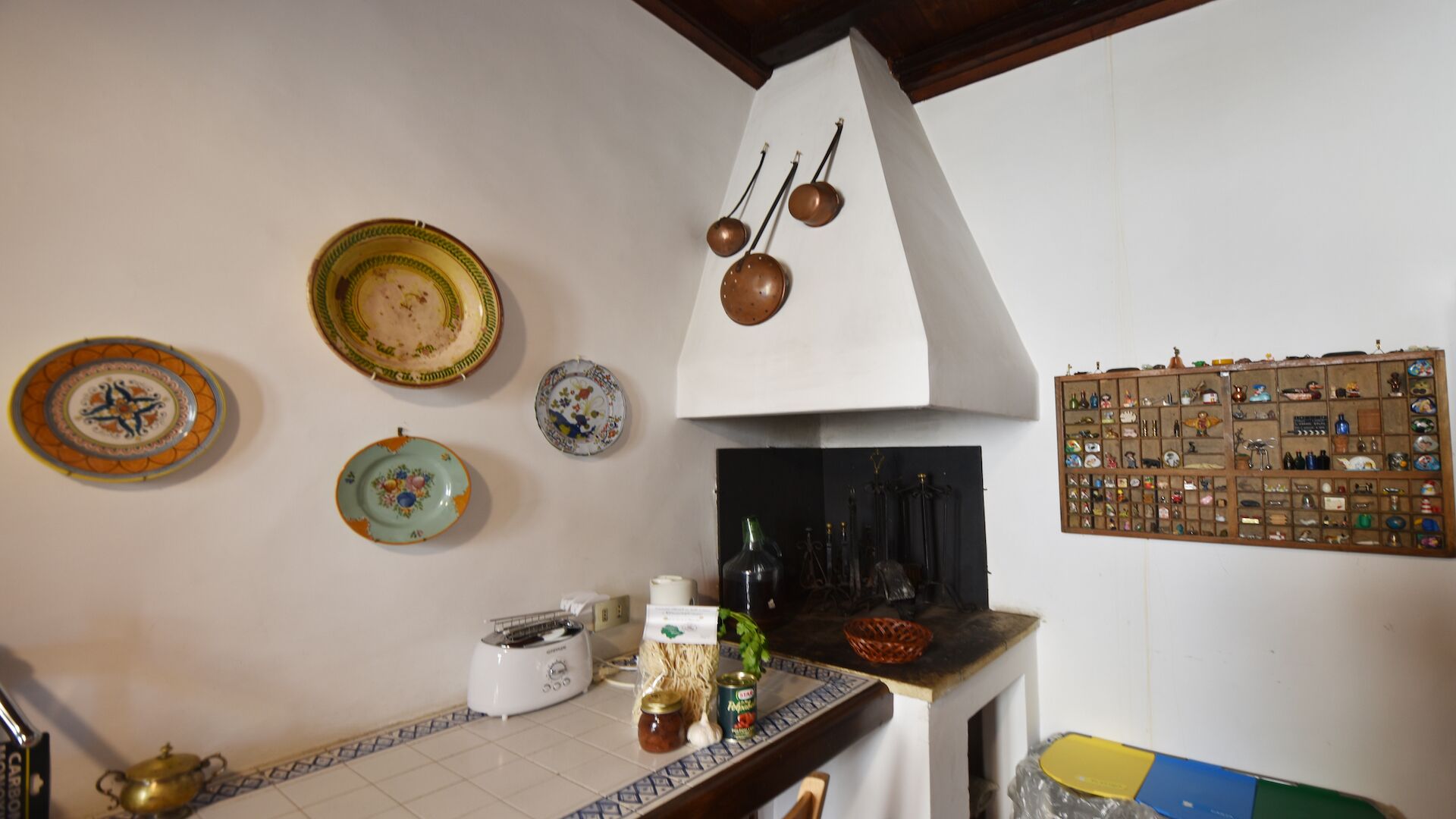 Una cucina con piastrelle a mosaico, un fornello e diversi utensili da cucina.