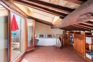A cozy attic bedroom with a skylight, a bed, a small table, and a bookshelf. - TOP-ROOF LARGE APARTMENT IN SPOLETO CITY CENTER, QUIET AND COZY TO FEEL AT HOME (Spoleto)
