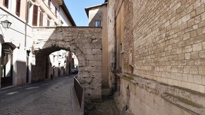 A cobblestone street with an arched stone bridge, historic buildings, and a narrow alleyway. - TOP-ROOF LARGE APARTMENT IN SPOLETO CITY CENTER, QUIET AND COZY TO FEEL AT HOME (Spoleto)